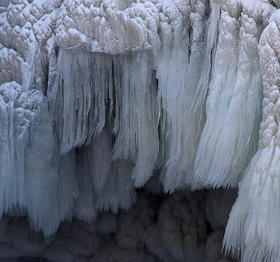 [Long, thin, needle-like icicles hanging from the larger icicles.]